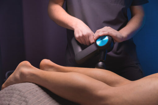 Rehabilitation. Massage therapist performs prophylactic percussive massage.